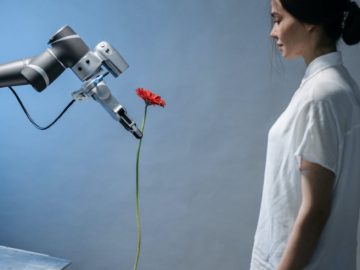 a robot giving a woman a flower